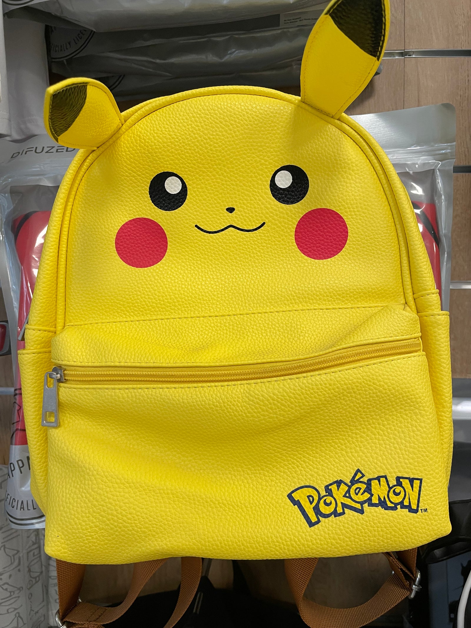 Foto reale dello zaino Pokémon Pikachu giallo: vista frontale con orecchie, tasca esterna e logo Pokémon